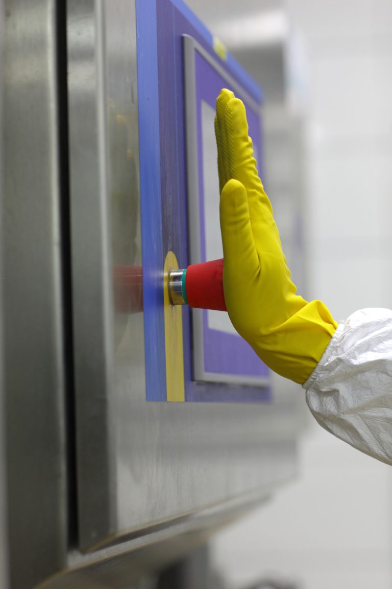 Worker pressing emergency button in factory