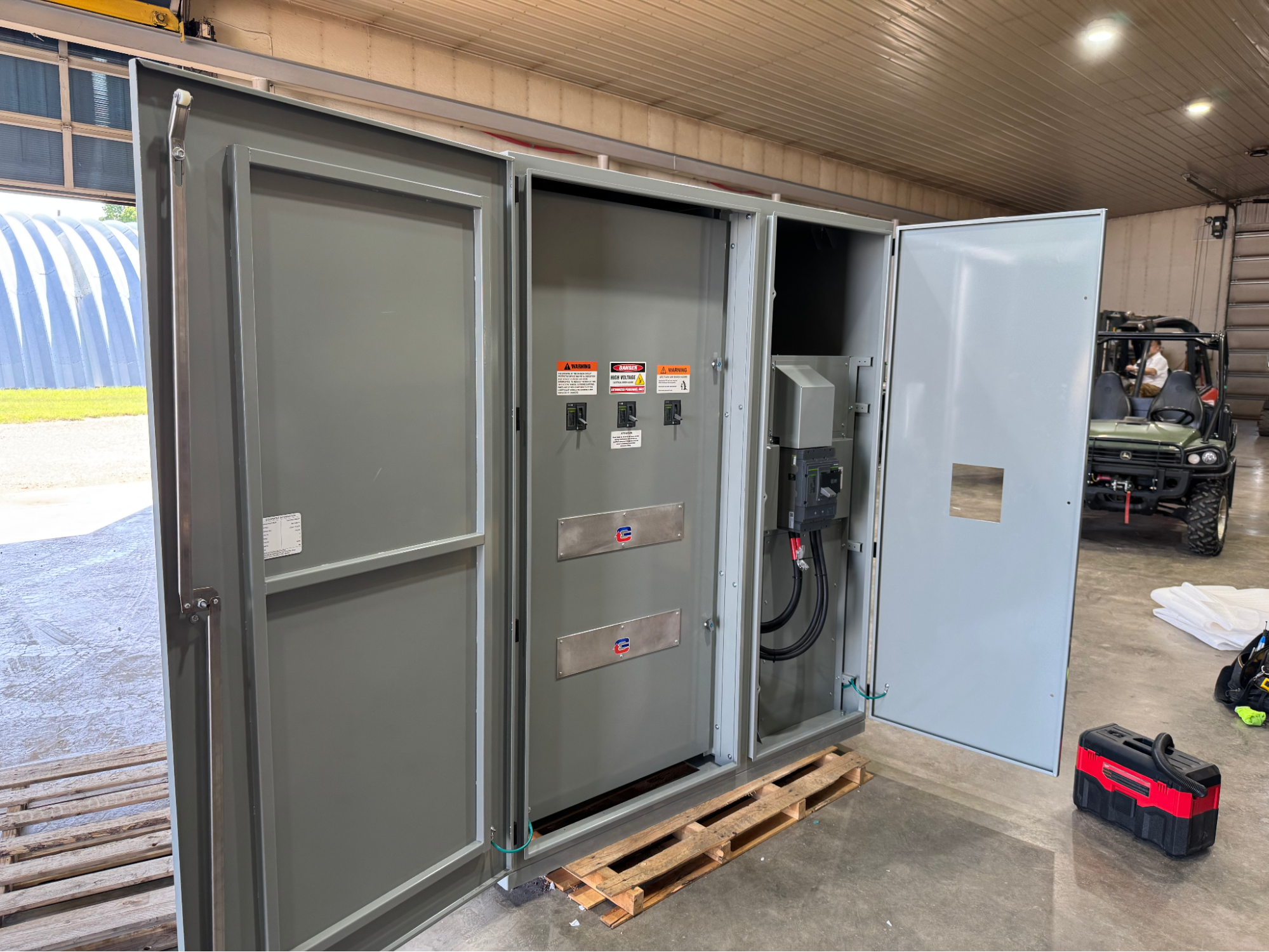 A custom MDP design-build electrical panel with open doors showing circuit breakers and wiring inside an industrial facility.